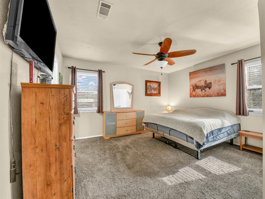 325 Huggins Drive Springtown, TX 76082 - Photo 14 of 28 a spacious bedroom with a bed and a flat screen tv