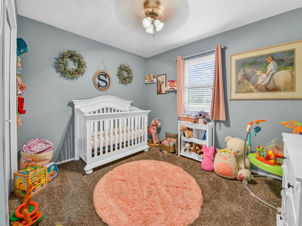 325 Huggins Drive Springtown, TX 76082 - Photo 18 of 28 a bedroom with furniture and a baby crib