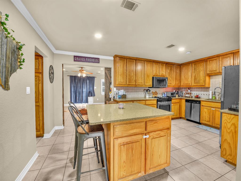 325 Huggins Drive Springtown, TX 76082 - Photo 28 of 28 a open kitchen with cabinets a refrigerator and chairs