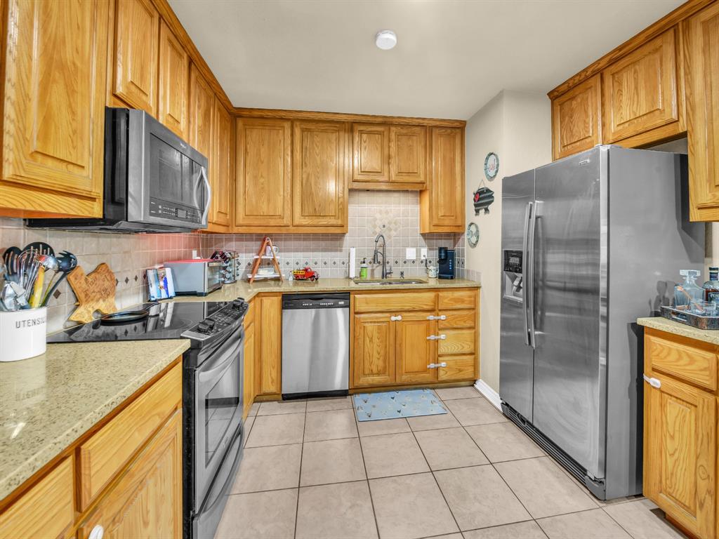 325 Huggins Drive Springtown, TX 76082 - Photo 7 of 28 a kitchen with a sink a refrigerator and cabinets