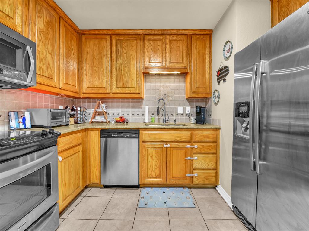 325 Huggins Drive Springtown, TX 76082 - Photo 8 of 28 a kitchen with stainless steel appliances granite countertop a refrigerator and cabinets