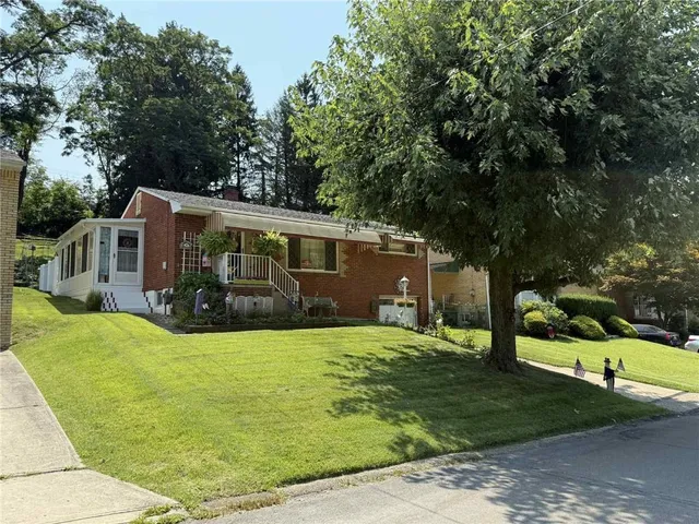 a view of a house with backyard and tree