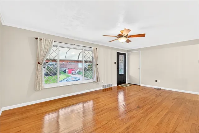 wooden floor in an empty room with a window