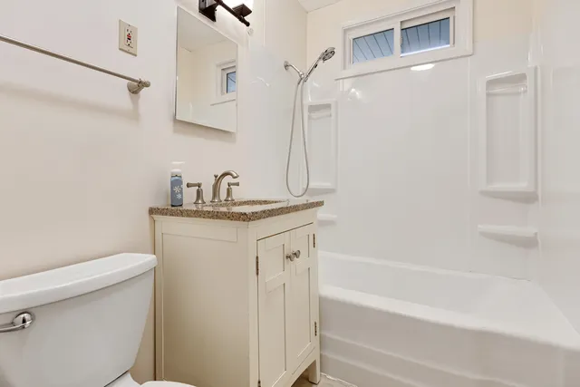 a bathroom with a granite countertop sink toilet and shower
