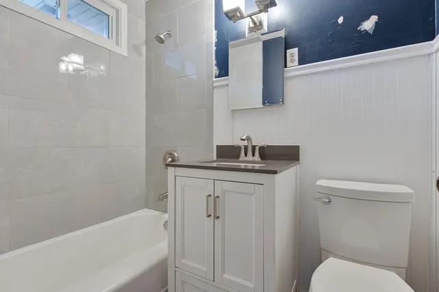 a bathroom with a granite countertop sink toilet and shower