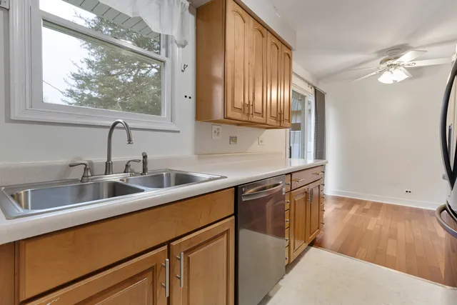a kitchen with stainless steel appliances granite countertop a sink a stove and a wooden floors