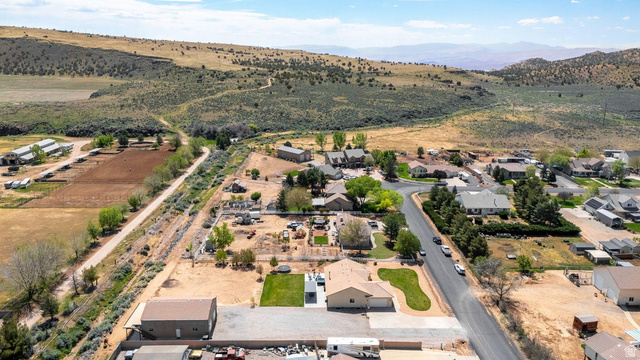 7776 Wagon Road East St. George, UT 84770 - Photo 73 of 76 Aerial view of property's location featuring rural landscape, a mountain backdrop, and nearby suburban area