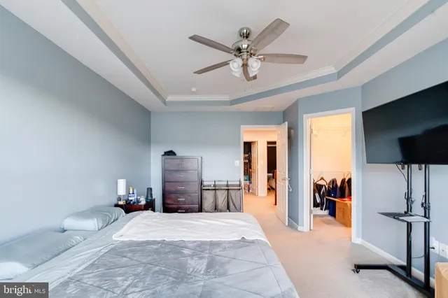 a bedroom with a large bed and a chandelier