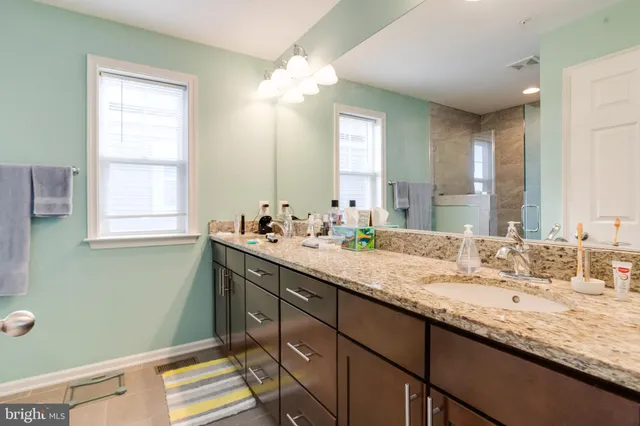 a bathroom with a granite countertop sink and a mirror
