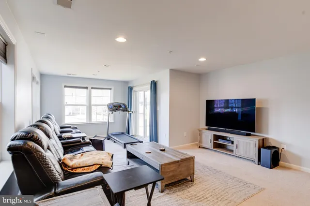 a living room with furniture a flat screen tv and a window