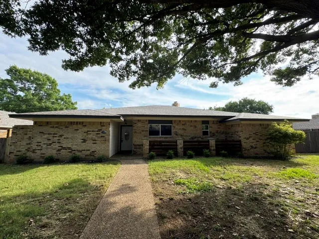 a front view of house with yard and tree in it