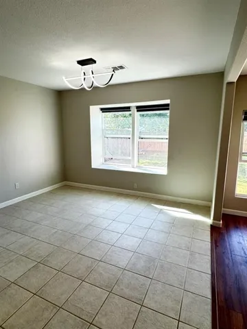 a view of an empty room with window and stairs