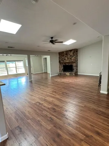a view of empty room with wooden floor and fireplace