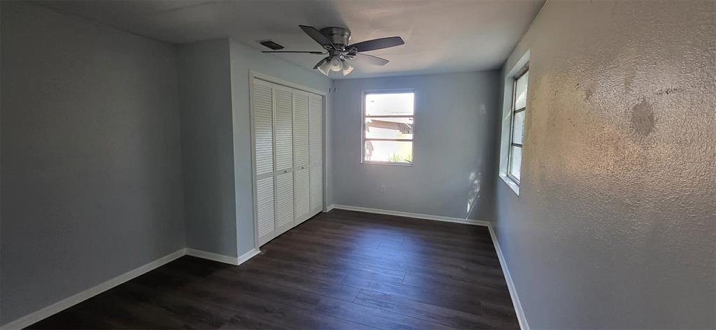 14761 Southwest 35th Terrace Road Ocala, FL 34473 - Photo 12 of 13 an empty room with wooden floor fan and windows