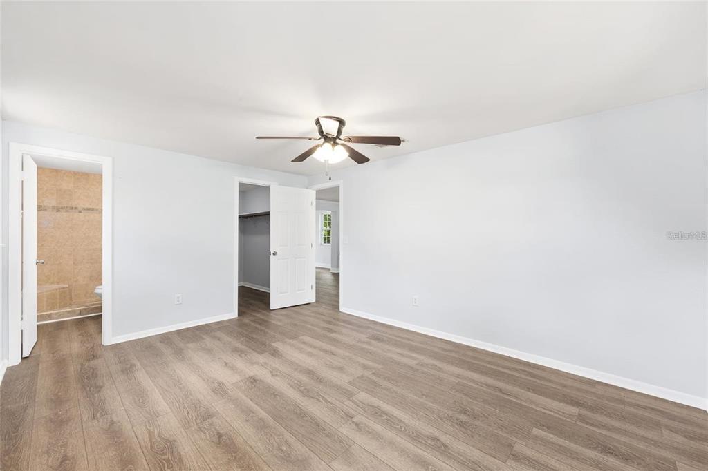 14761 Southwest 35th Terrace Road Ocala, FL 34473 - Photo 7 of 13 a view of a room with wooden floor and ceiling fan
