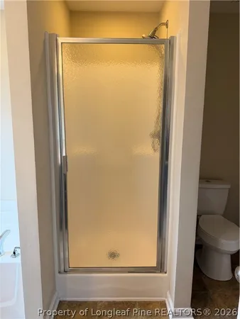 a bathroom with a glass door shower and a toilet