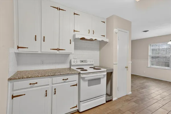 a kitchen with granite countertop white cabinets and white appliances