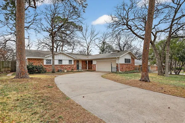 a front view of a house with yard and trees