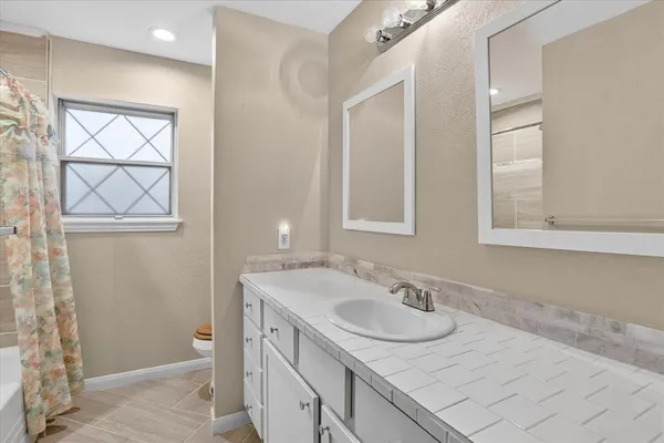 a bathroom with a granite countertop sink and a mirror