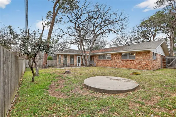 a view of a house with backyard and trees