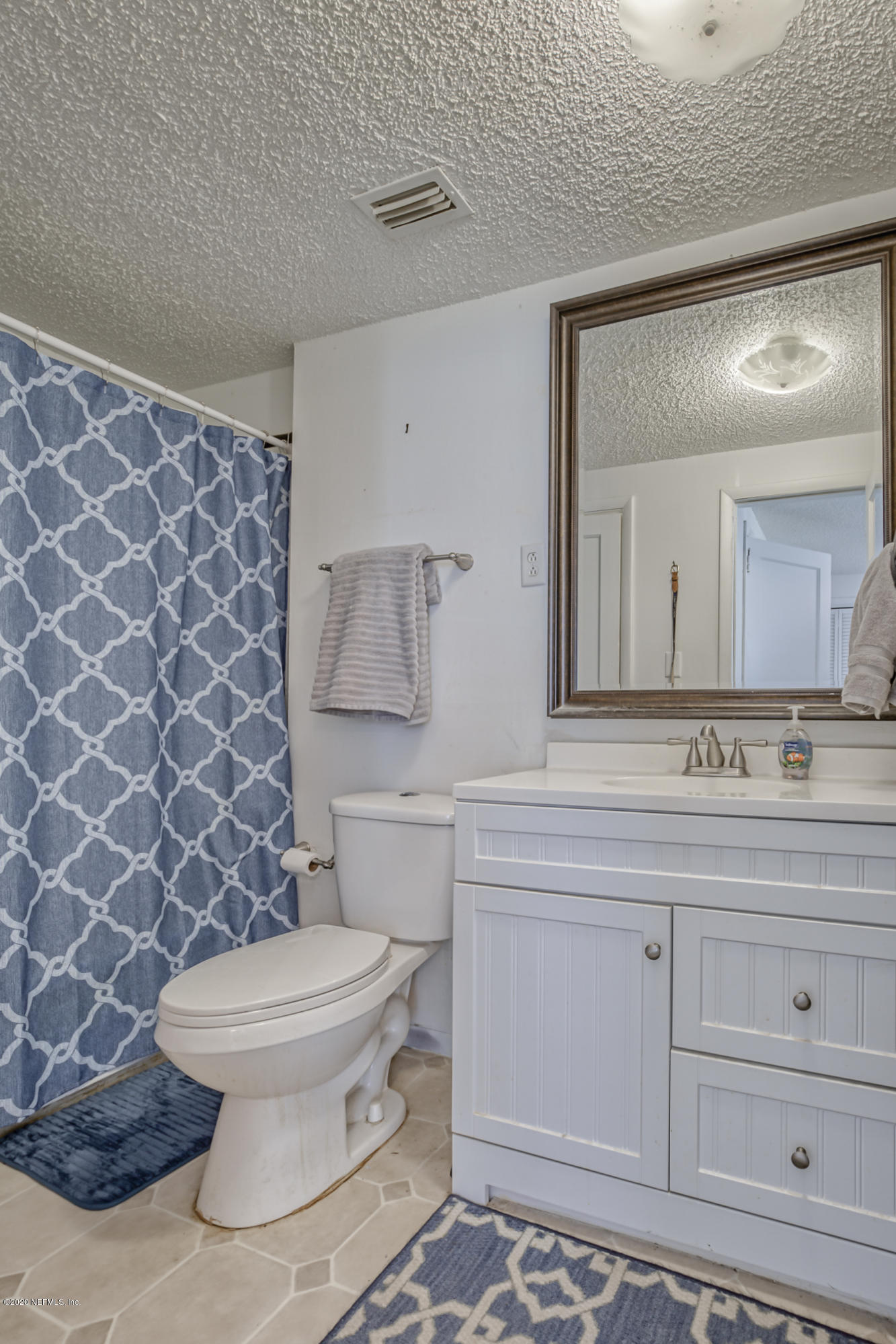 4571 Appleton Avenue Jacksonville, FL 32210 - Photo 17 of 30 a bathroom with a granite countertop toilet a sink and a mirror