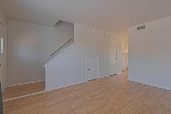 a view of an empty room with wooden floor