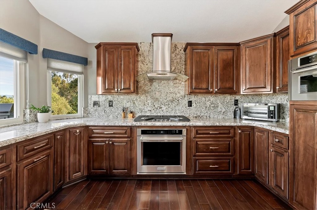 1793 Praed Street Riverside, CA 92503 - Photo 21 of 75 a kitchen with stainless steel appliances granite countertop wooden cabinets a sink and dishwasher with wooden floor