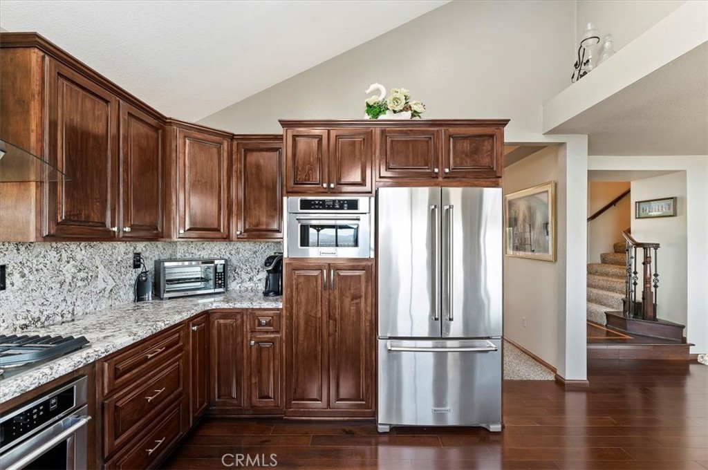 1793 Praed Street Riverside, CA 92503 - Photo 22 of 75 a kitchen with stainless steel appliances granite countertop a refrigerator oven a sink dishwasher and wooden cabinets with wooden floor