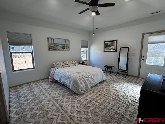 300 Southeast Sandstone Court Cedaredge, CO 81413 - Photo 23 of 38 a spacious bedroom with a bed and a chandelier