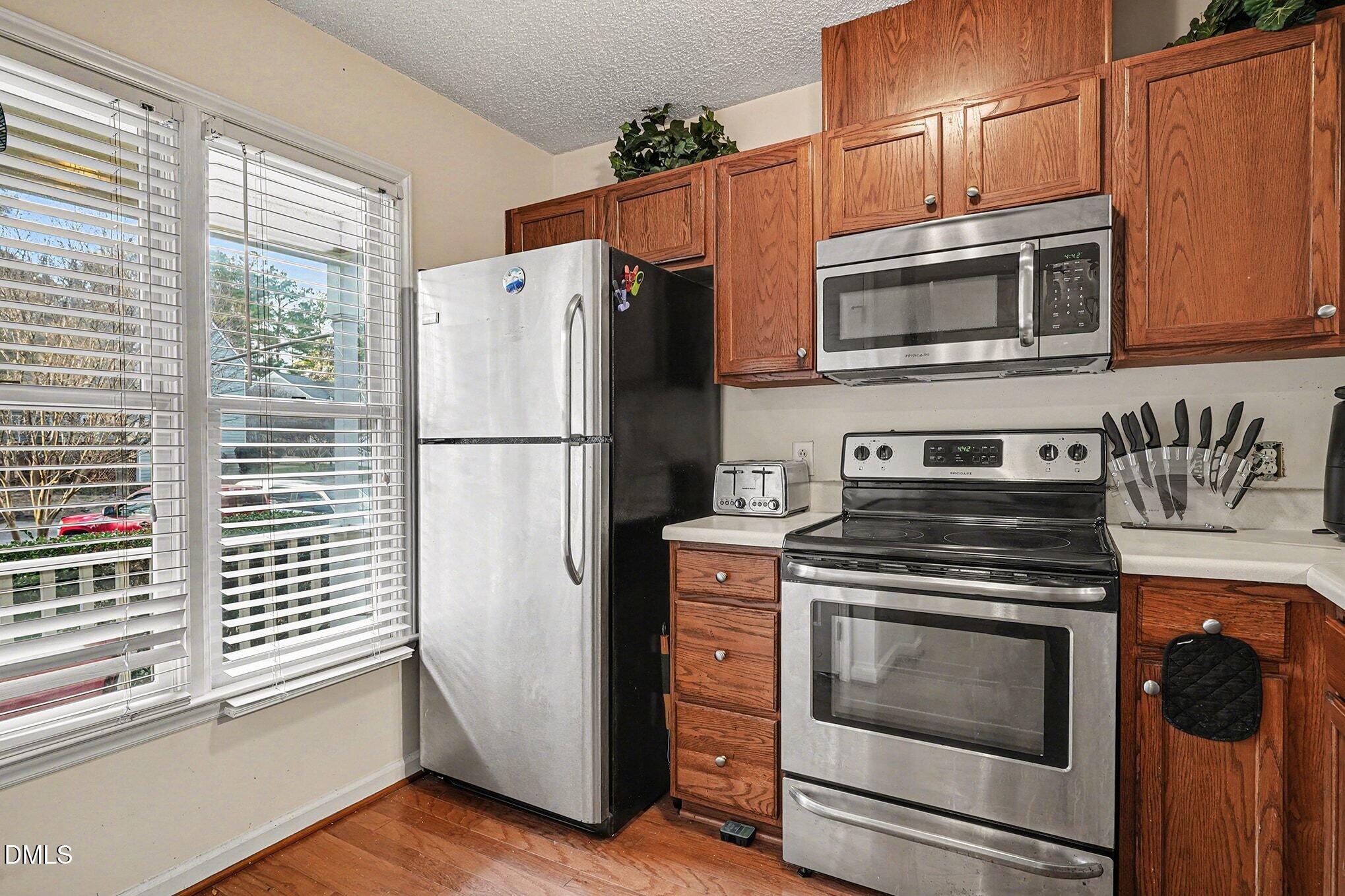 1502 Oakland Hills Way Raleigh, NC 27604 - Photo 11 of 26 a kitchen with stainless steel appliances white cabinets and a stove
