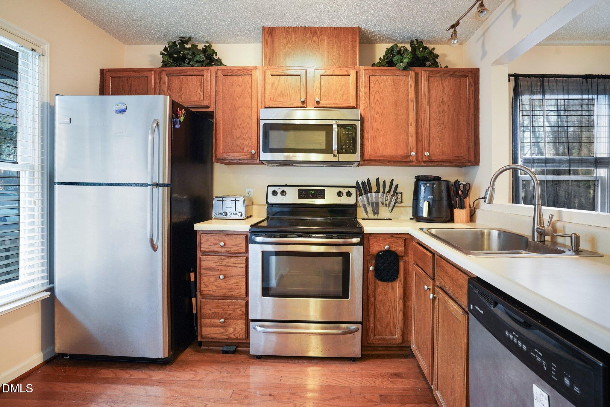 1502 Oakland Hills Way Raleigh, NC 27604 - Photo 12 of 26 a kitchen with a refrigerator and a sink