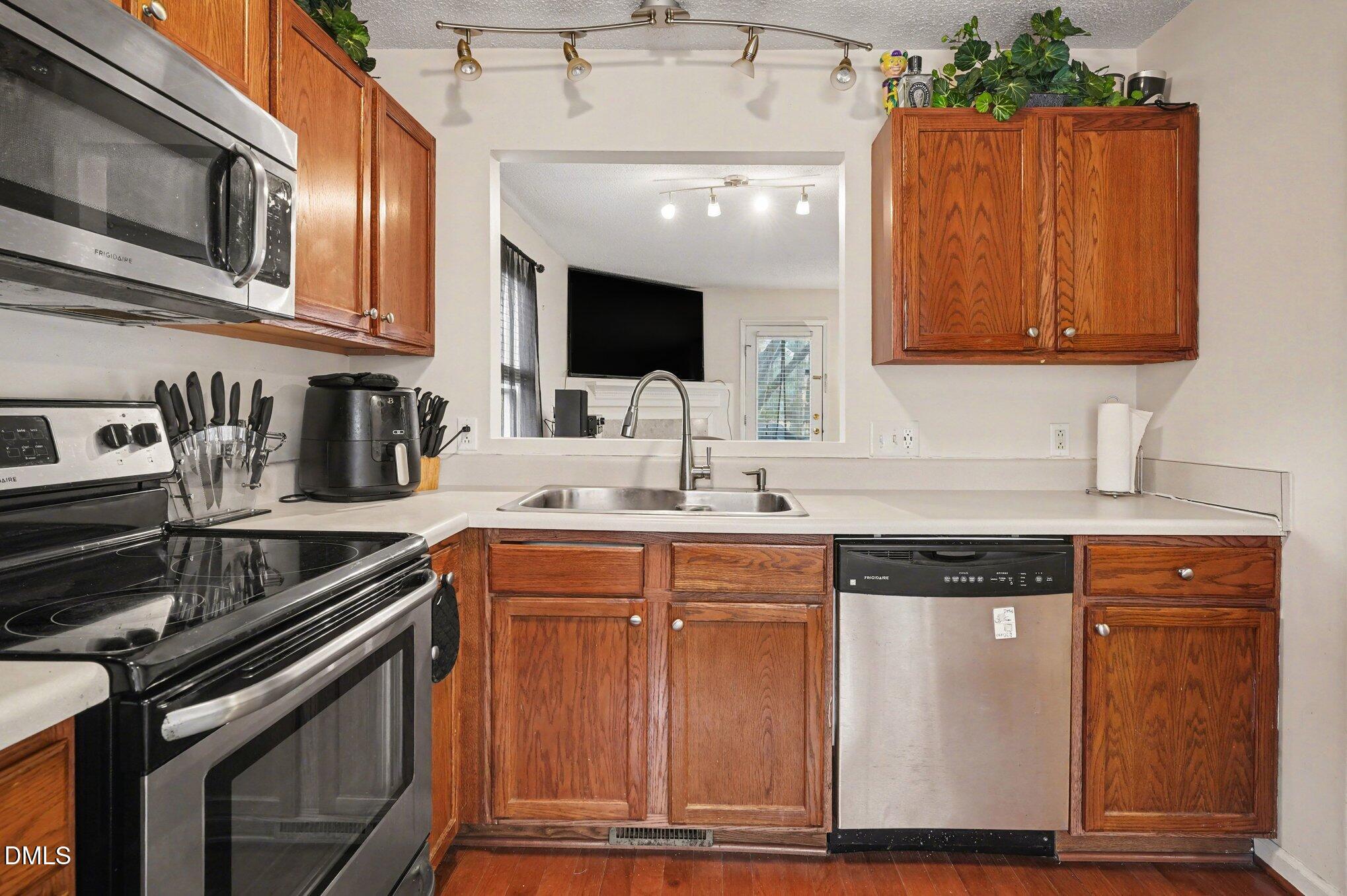 1502 Oakland Hills Way Raleigh, NC 27604 - Photo 13 of 26 a kitchen with stainless steel appliances granite countertop a sink stove and microwave
