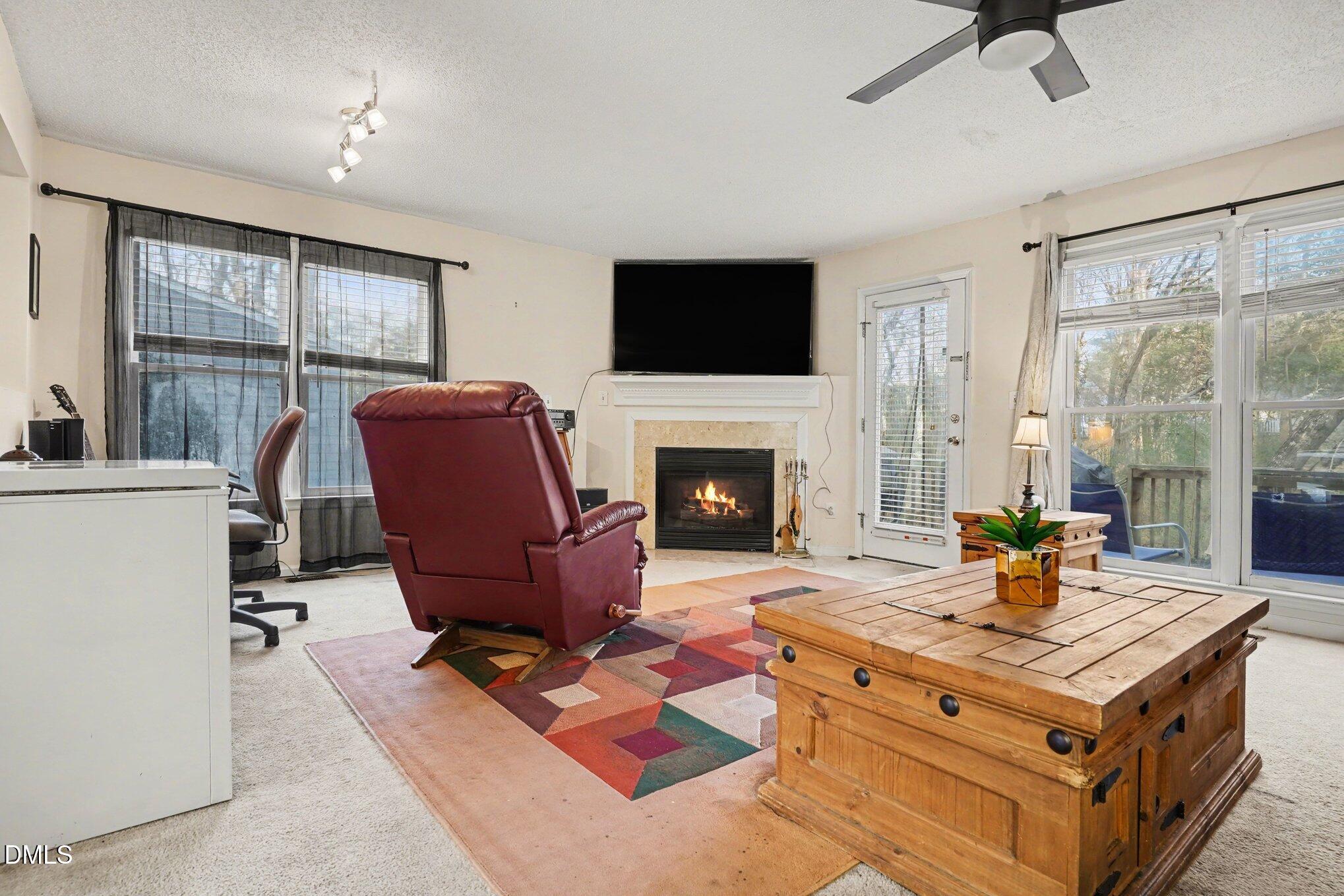 1502 Oakland Hills Way Raleigh, NC 27604 - Photo 6 of 26 a living room with furniture a flat screen tv and a fireplace