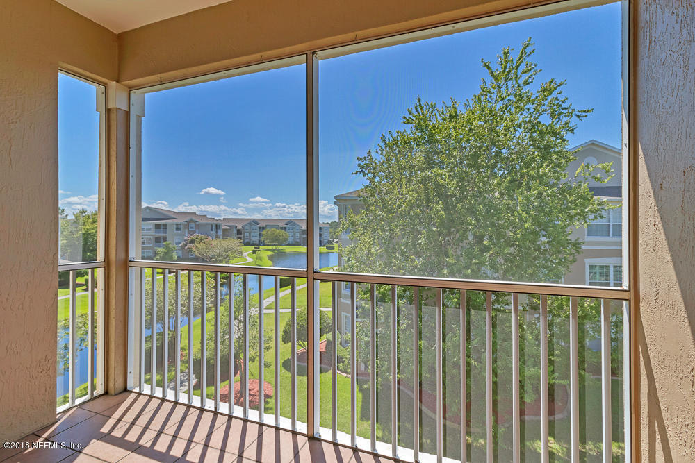 7990 Baymeadows Road East, Unit 211 Jacksonville, FL 32256 - Photo 19 of 21 a view of a balcony with a floor to ceiling window and wooden fence