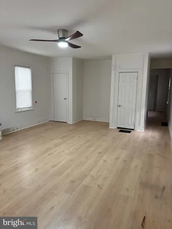 an empty room with a ceiling fan and window