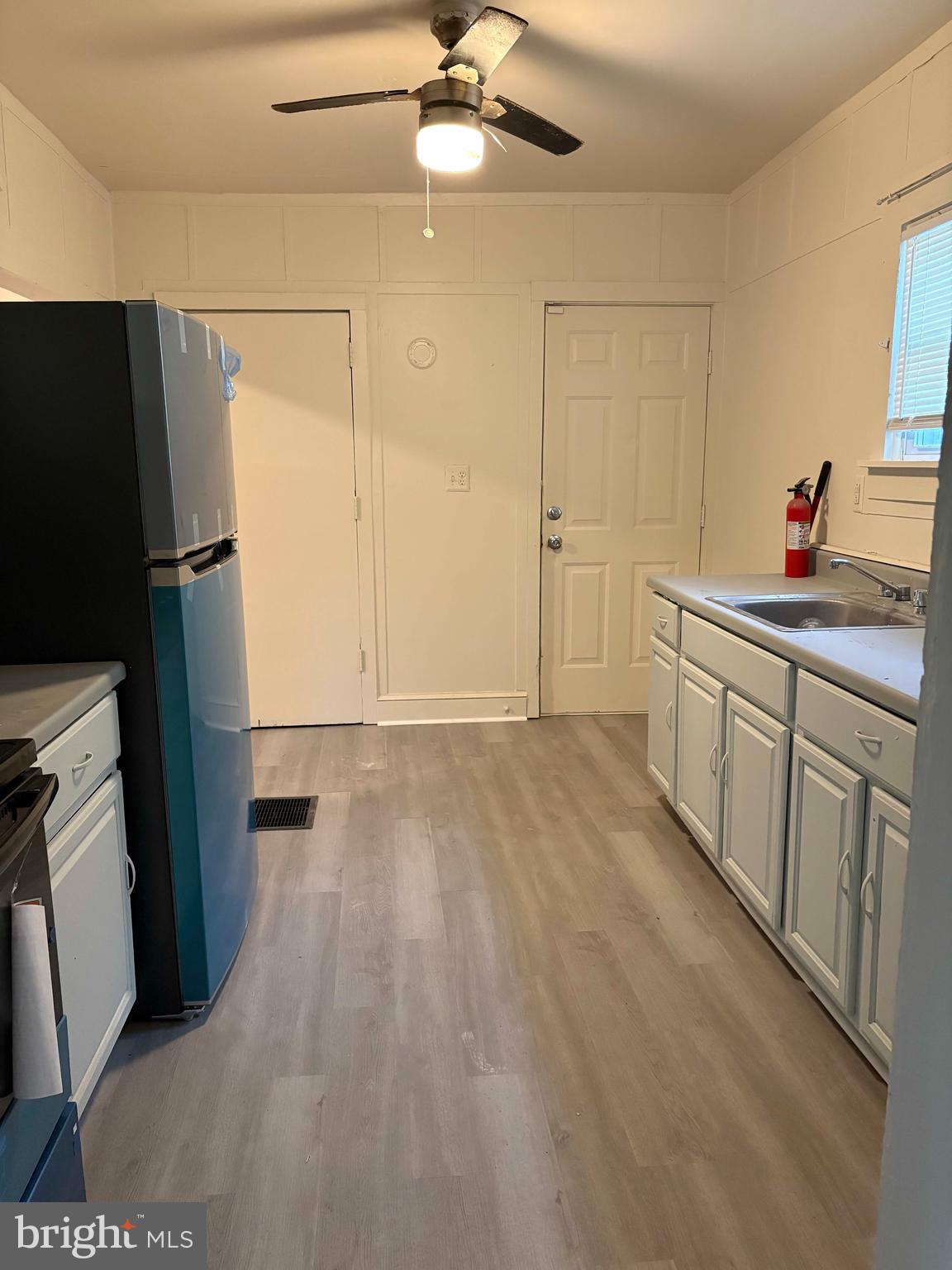 210 Wesley Street Salem, NJ 08079 - Photo 6 of 17 a view of a kitchen with a sink and dishwasher a refrigerator with wooden floor