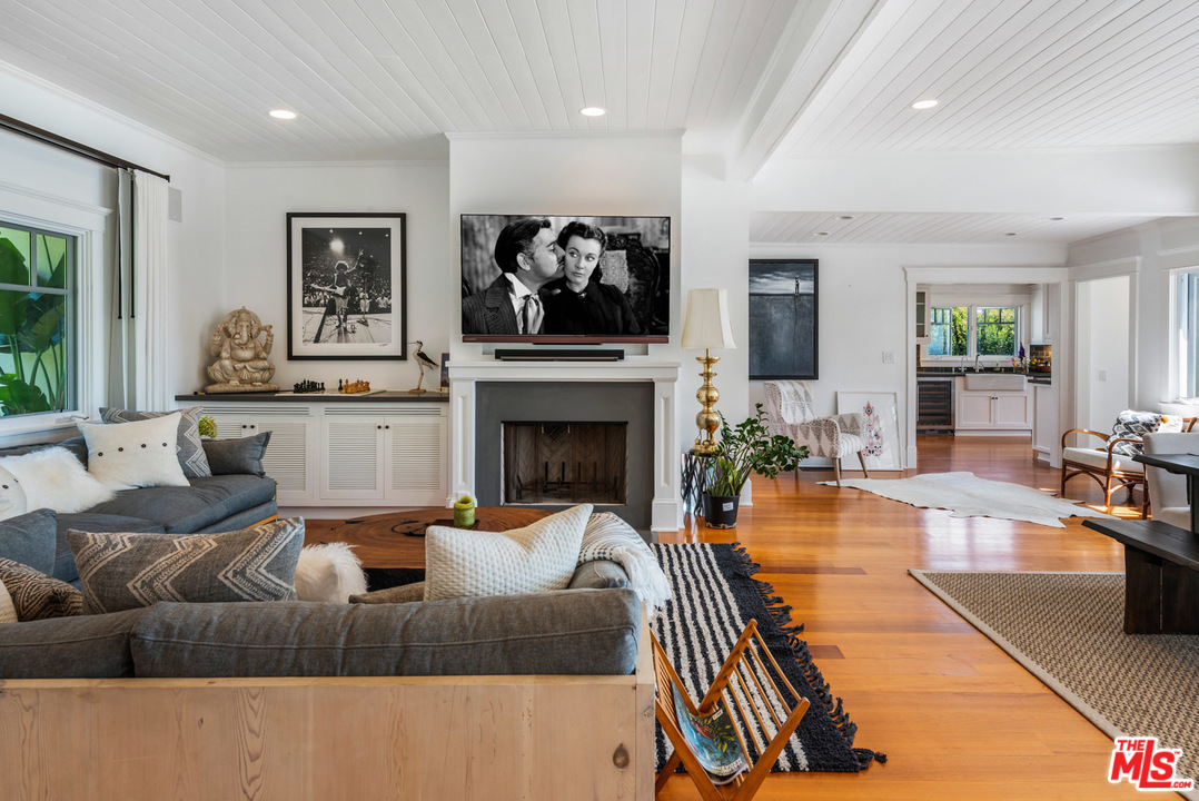 7163 Birdview Avenue Malibu, CA 90265 - Photo 15 of 22 a living room with furniture a flat screen tv and a fireplace