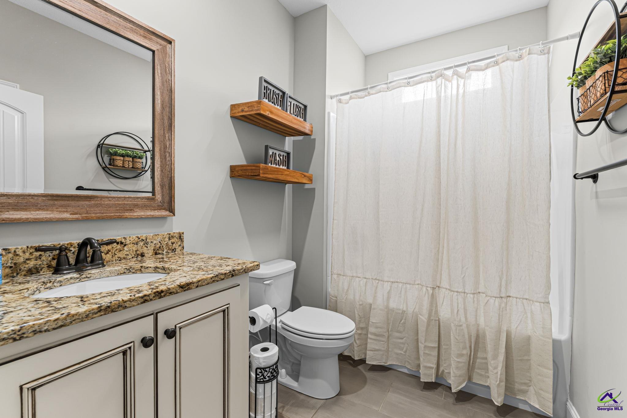 180 Woodland Trail Road Cochran, GA 31014 - Photo 18 of 25 a bathroom with a granite countertop sink toilet and shower