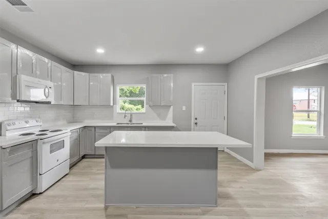 a kitchen with a sink microwave and cabinets