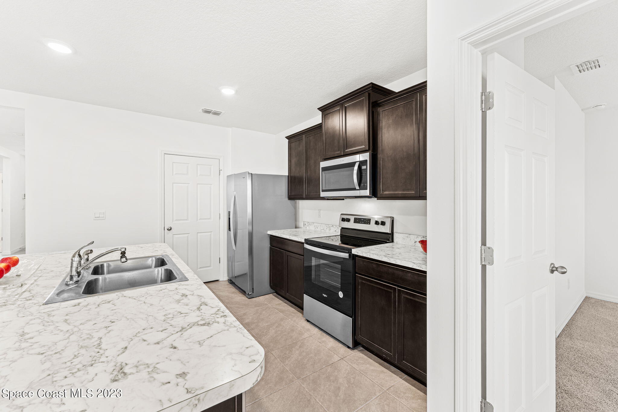 992 Trinity Street Rockledge, FL 32955 - Photo 3 of 19 a kitchen with a sink stove and refrigerator