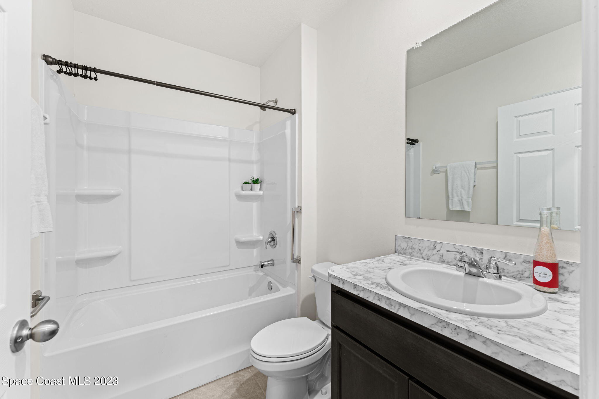992 Trinity Street Rockledge, FL 32955 - Photo 8 of 19 a bathroom with a granite countertop sink a toilet and a mirror