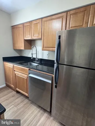 a kitchen with granite countertop a sink a stove and cabinets