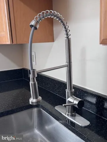 a kitchen with stainless steel appliances granite countertop a refrigerator a stove and a sink with wooden cabinets