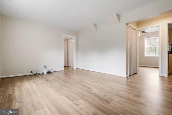 a view of an empty room with closet and a window