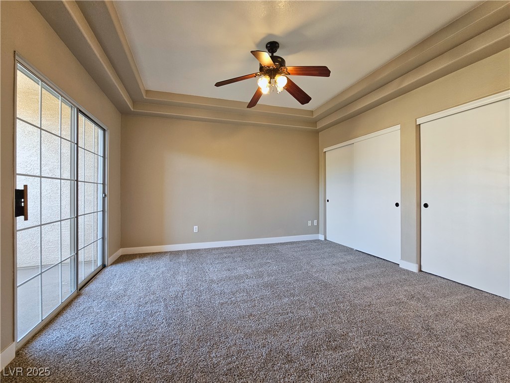 1851 Hillpointe Road, Unit 2124 Henderson, NV 89074 - Photo 17 of 24 Unfurnished bedroom with a tray ceiling, carpet, baseboards, and multiple closets