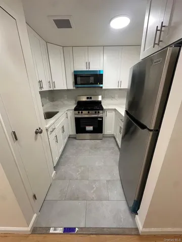 a kitchen with granite countertop a refrigerator and a sink