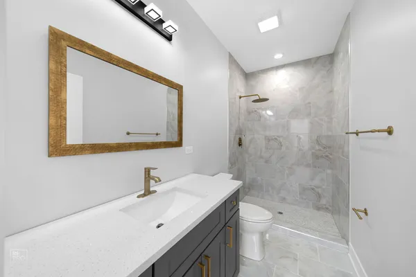 a bathroom with a double vanity sink toilet and shower