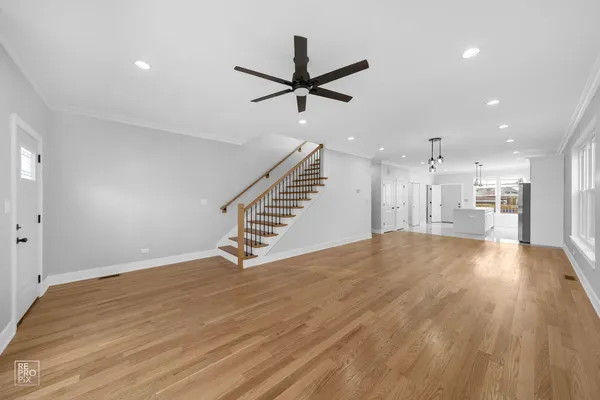 a view of empty room with wooden floor and ceiling fan