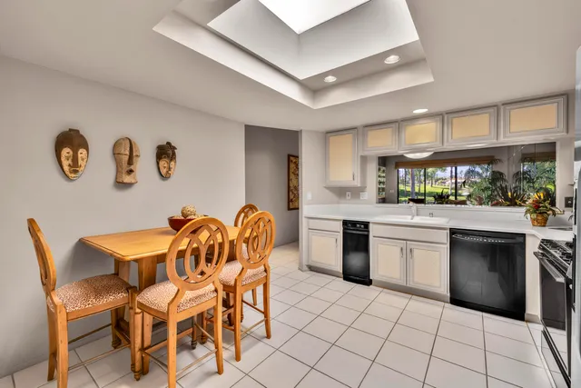 a kitchen with stainless steel appliances a refrigerator a stove a sink dishwasher and white cabinets with wooden floor