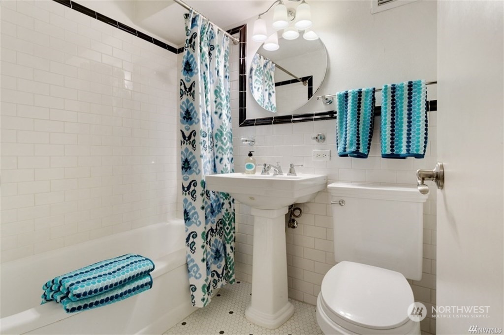 1105 Spring Street, Unit 305 Seattle, WA 98104 - Photo 11 of 25 a bathroom with a sink a mirror and toilet